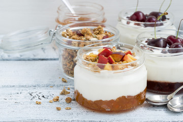 dessert with cream, peach and cherry jam in glass jars 