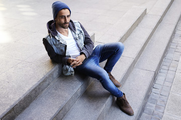 Cool young guy sitting on step