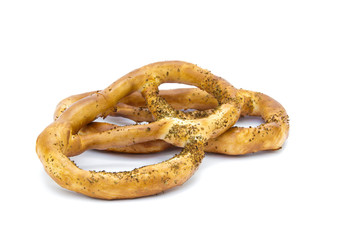 close-up of two pretzels, brown and covered with poppy seeds, on a white background
