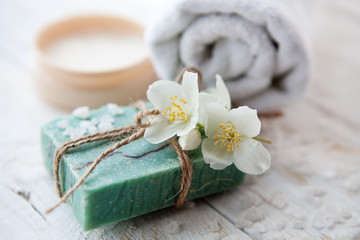 Obraz na płótnie Canvas Sea salt, beauty cream with jasmine flower and white towels on wooden table