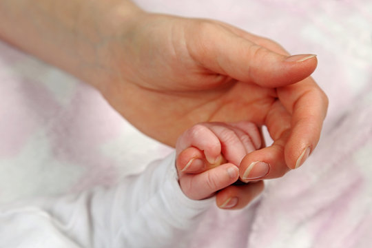 Baby hält Mamas Hand