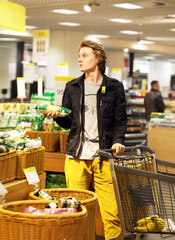 Young man with a shopping cart in a supermarket 