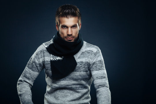 Handsome Man Posing In A Sweater And A Scarf Around The Neck