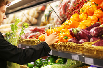 Young man with a shopping cart in a supermarket 