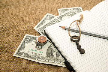 Opened notebook, pencil and money on the old tissue