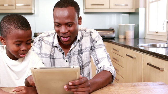 Father using tablet with his son 
