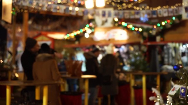People visit  Christmas Fair in old town at evening. Defocused