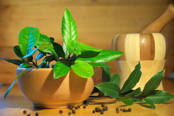 Bay leaves in wooden bowl with pepper 