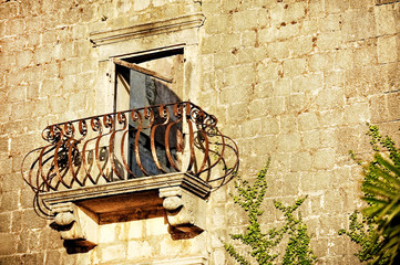 Abandoned house with rusty wrought iron balcony