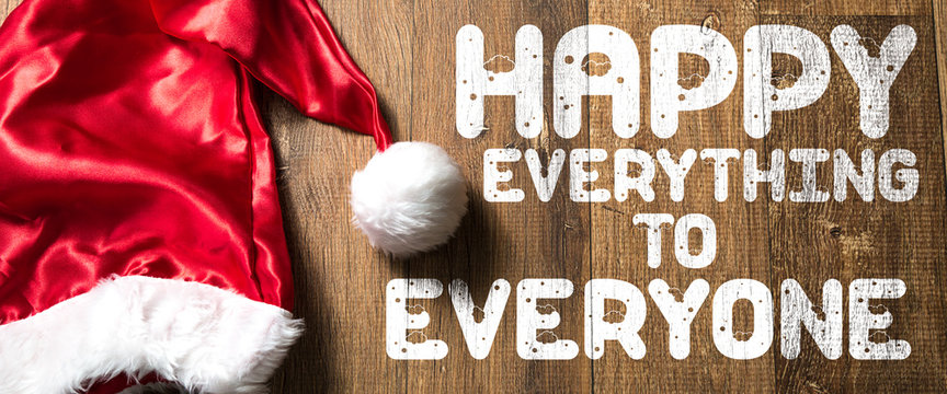 Happy Everything to Everyone written on wooden with Santa Hat
