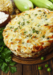 Casserole of pasta with green peas, zucchini and curd