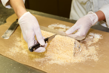 Female pastry chef is portioning the dessert