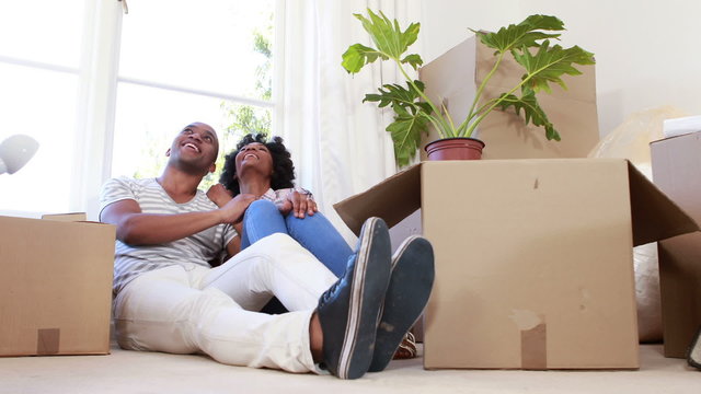 Smiling couple unpacking cardboard boxes