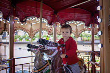 Fototapeta na wymiar Sweet boy, riding in a train on a merry-go-round, carousel attra