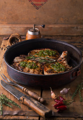 Grilled pork chop with spices in a frying pan