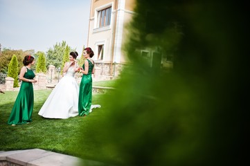 Bride in the courtyard of the mansion house with bridesmaids