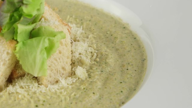 Broccoli cream soup with roasted rusks and leaf of salad