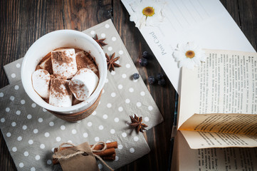 Hot chocolate drink with marshmallow and a book