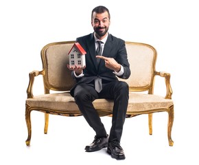 Businessman holding a little house
