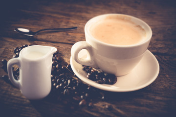 cappuccino cup and coffee beans - tilt shift effect photo