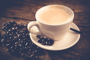 cappuccino cup and coffee beans - tilt shift effect photo