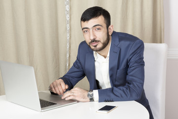 Portrait of a man with a laptop. A man sits at a Desk and working. 