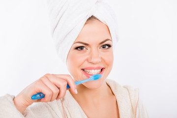 Pretty girl brushes her teeth on a white background