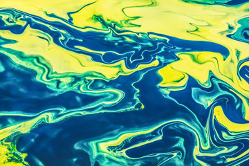 Yellow and green paint flowing and mixing texture.