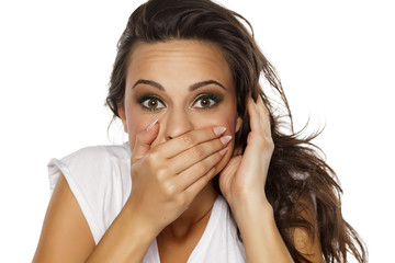 pretty embarrassed young woman covering her mouth with her hand