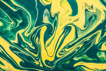 Yellow and green paint flowing and mixing texture.