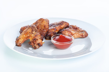 Crispy fried chicken wings with ketchup on a white background