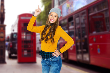 Fototapeta premium happy young woman or teen girl pointing finger up
