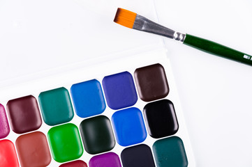 Watercolor paints and brush on a white background