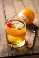 Old fashioned cocktail with cherry and orange peel