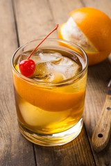 Old fashioned cocktail with cherry and orange peel