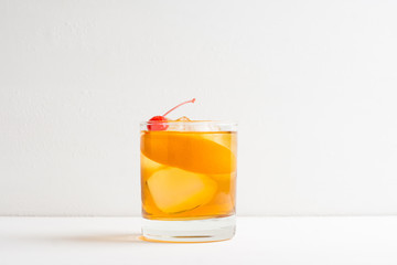 Old fashioned cocktail with cherry and orange peel