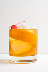 Old fashioned cocktail with cherry and orange peel