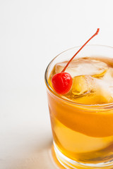 Old fashioned cocktail with cherry and orange peel