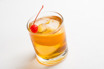 Old fashioned cocktail with cherry and orange peel