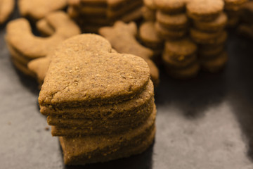 baked gingerbread in the shape of hearts poised to pile before decorating