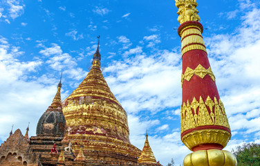 Fototapeta premium Myanmar, Bagan, the golden pagoda in the plain with thousand of 880-year old temple ruins.