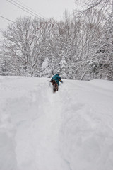 young boy walking down a snow covered rural road in a snow storm