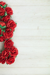 Bunch of red roses in light wood background