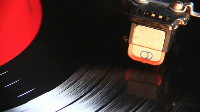 Vinyl Turntable. Vinyl turntable plays a record with the orange round sticker