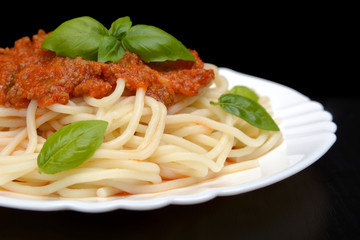 Close up pasta with bolognese sauce on black,cropped shot