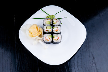 Decorated sushi served on a white plate. The meal is ready for eating.