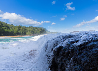 Naklejka na ściany i meble Powerful waves flow over rocks at Lumahai Beach, Kauai