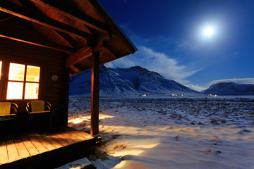 Cottage on a background of mountains in the moonlight. South Iceland. Travel concept