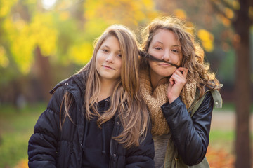 Two young teenager in the city park at autumn