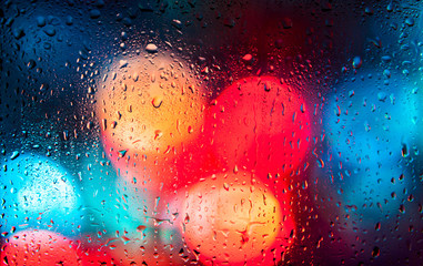 Night city lights through a wet window